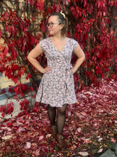 Load image into Gallery viewer, Wrap dress on a model. Red background with fallen autumn leaves. 