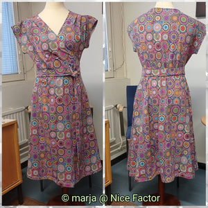 Wrap dress in colorful print shown on a mannequin. On the right picture front of the dress, on the left picture back of the dress.
